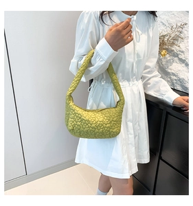 Sac croissant matelassé vert avocat chic porté avec une robe blanche pour un look frais