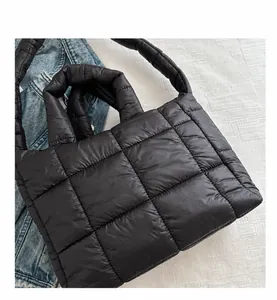 Detalle del bolso tote acolchado negro de nailon con asas superiores y correa de hombro