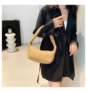 Détail du sac plissé marron clair avec texture matelassée florale 3D et forme en croissant