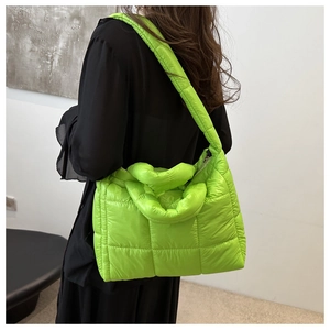Detail of neon green quilted puffer tote bag with high-gloss nylon and padded squares