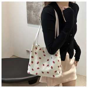Detail der Cord-Beuteltasche mit Erdbeerdruck, Textur und schmalem Schultergurt