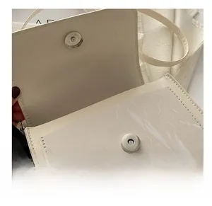 Detail of the high-quality magnetic clasp on a cream PU leather small square bag