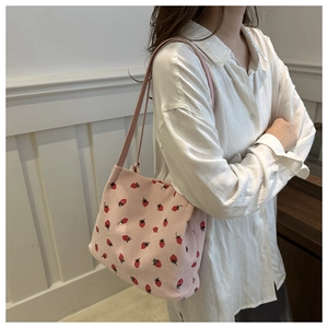 Detail der rosa gestrickten Beuteltasche mit Erdbeermuster und schmalem Schultergurt
