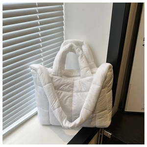 Detail der weißen gesteppten Puffertasche mit Karomuster und gepolstertem Griff