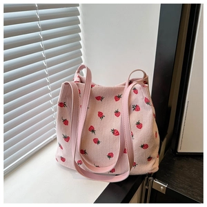 Detail der rosa Cord-Einkaufstasche mit Erdbeermustern und Leder-Schulterriemen