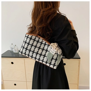Detail van zwart-witte tweed shopper met bruine lederen bies en decoratieve zijden sjaal