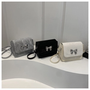 Three textures of butterfly buckle crossbody bags in marble grey, black, and beige cream