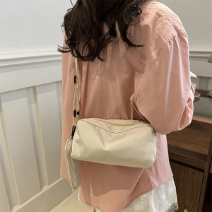 Minimalistische beige Umhängetasche mit passender Geldbörse am Model präsentiert