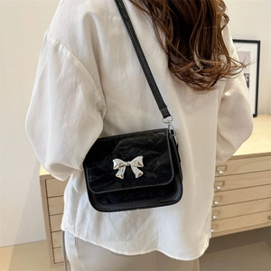 Chic black butterfly crossbody bag in glossy faux leather with silver buckle and thin strap