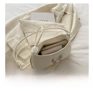 Detailed interior view showing capacity of the cream shoulder bag with butterfly lock