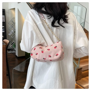 Nahaufnahme der rosa Cord-Schultertasche mit Erdbeermuster und goldener Kette