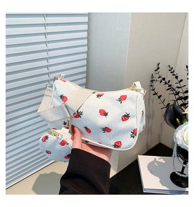 Detalle del bolso media luna de pana blanca con estampado de fresas y monedero redondo