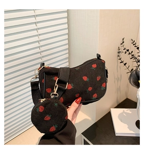 Detail of black corduroy crescent bag with strawberry print and gold metal buckle