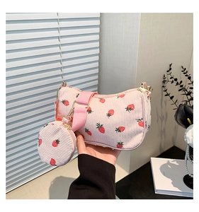 Detalle de bolso de hombro de pana rosa con fresas y pequeño monedero a juego