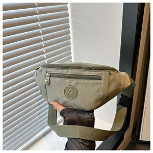 Détail du sac banane de sport vert olive avec deux poches zippées et boucle en plastique noir