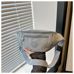 Détail du sac banane de sport en nylon avec double fermeture éclair et badge sportif