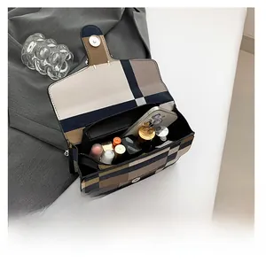 Open view of flap crossbody bag showing internal space for phone and makeup items