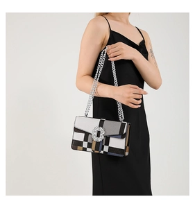Detail of crossbody bag featuring crystal buckle and colorful striped geometric pattern