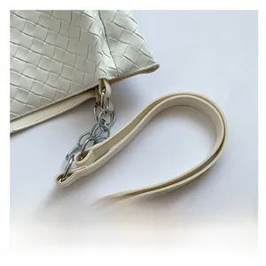 Detail of white woven leather tote featuring silver metal chain and shoulder strap