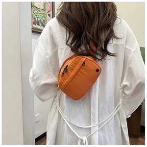 Rückansicht eines Modells mit einer leuchtend orangefarbenen Nylon-Umhängetasche mit Reißverschluss