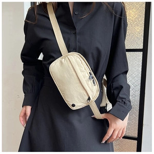 Detail der beigen Nylon-Umhängetasche mit Reißverschlussfächern und verstellbarem Gurt