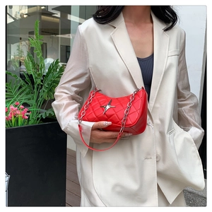 Detail of red quilted crescent bag with silver star ornament and leather chain strap