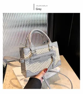 Detail of grey mini handbag with leather stitching and adjustable shoulder strap