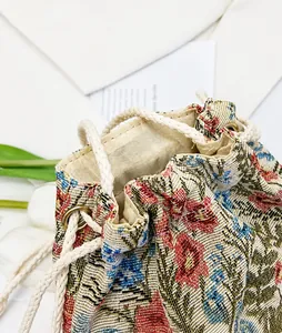 Close-up of ethnic floral embroidery and drawstring closure on canvas bucket bag
