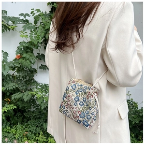 Detail of floral bucket bag with drawstring closure and colorful flower embroidery