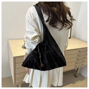 Détail du sac cabas en velours noir avec motifs de feuilles de bambou et gland noué