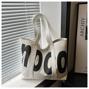 Dettaglio del logo hoco su una borsa tote bianca capiente con finitura testurizzata