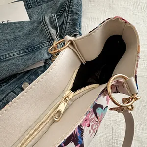 Detail of white tote bag showing smooth gold zipper closure and butterfly print canvas