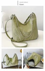Dettaglio della borsa hobo verde con texture goffrata, catena e tracolla regolabile