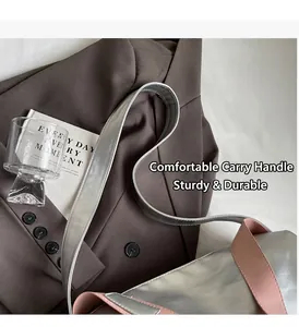 Detalle de bolso tote plateado metalizado con ribete de cuero rosa y correa ancha