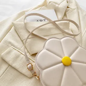 Detailed shot of white floral petal bag with yellow center on tweed fabric