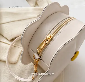 Detailed macro view of the cream flower-shaped bag with golden zipper and fine stitching