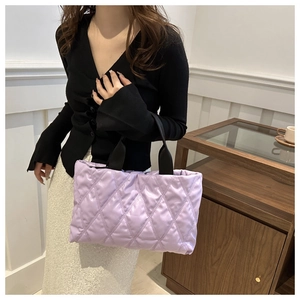 Detail of lavender quilted tote bag featuring black wide handle and soft down-like texture