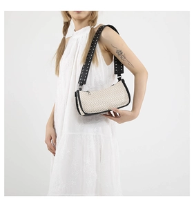 Dettaglio borsa intrecciata retro con tracolla in pelle nera borchiata e rivetti argento