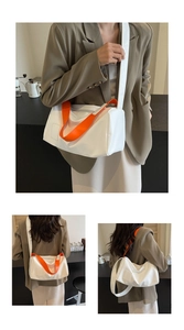 Detalle del bolso tote blanco con asas naranjas y correa larga ajustable para hombro