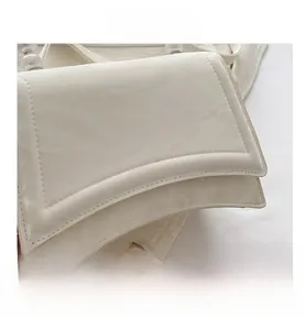 Dettaglio borsa in ecopelle bianco crema con manico di perle e cuciture rifinite