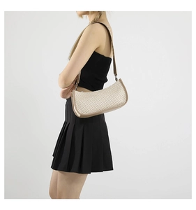 Dettaglio della borsa baguette beige intrecciata con tracolla regolabile indossata da modella