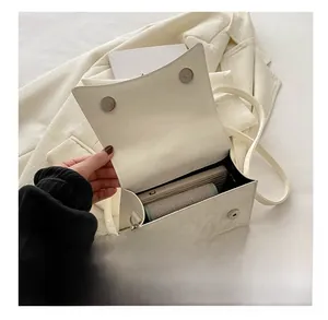 Dettaglio dell'interno della borsa a tracolla bianca con fibbie magnetiche e spazio interno