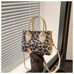 Detail der Leopardenmuster-Struktur und cremefarbenen Ledergriffe einer Mini-Tasche