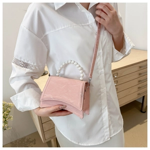 Borsa rosa con manico di perle, trama effetto marmo e silhouette a clessidra