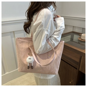 Détail du sac cabas rose en tissu froissé avec un charmant pompon blanc