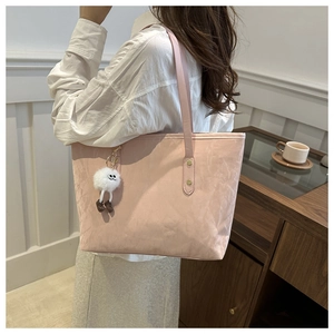 Détail du grand sac cabas rose avec breloque monstre en peluche sur bandoulière chic