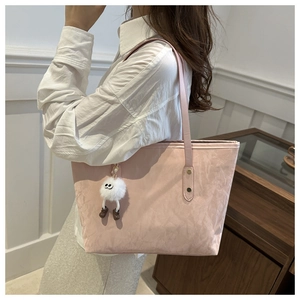 Sac fourre-tout rose plissé avec pendentif en peluche porté par un mannequin