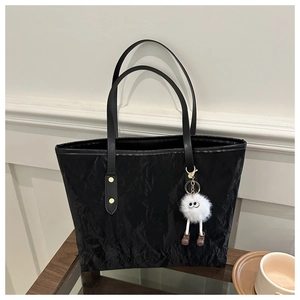 Détail du sac cabas noir à texture plissée et charmant pendentif monstre en peluche
