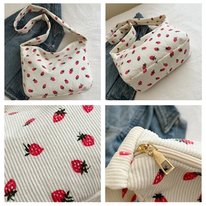 Vue détaillée du sac fourre-tout en velours côtelé blanc avec motif fraise et zip
