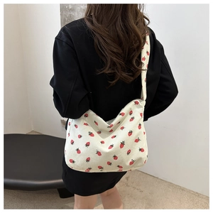 Détail de l'imprimé fraise sur sac cabas en velours côtelé avec large bandoulière